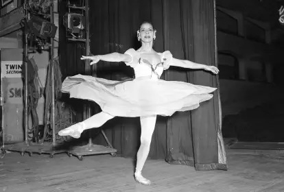 Alicia Alonso onstage as Giselle in a flowing white dress, arms raised in a dramatic pose