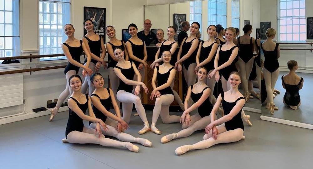 English National Ballet ensemble performing a full-cast scene under warm stage lighting