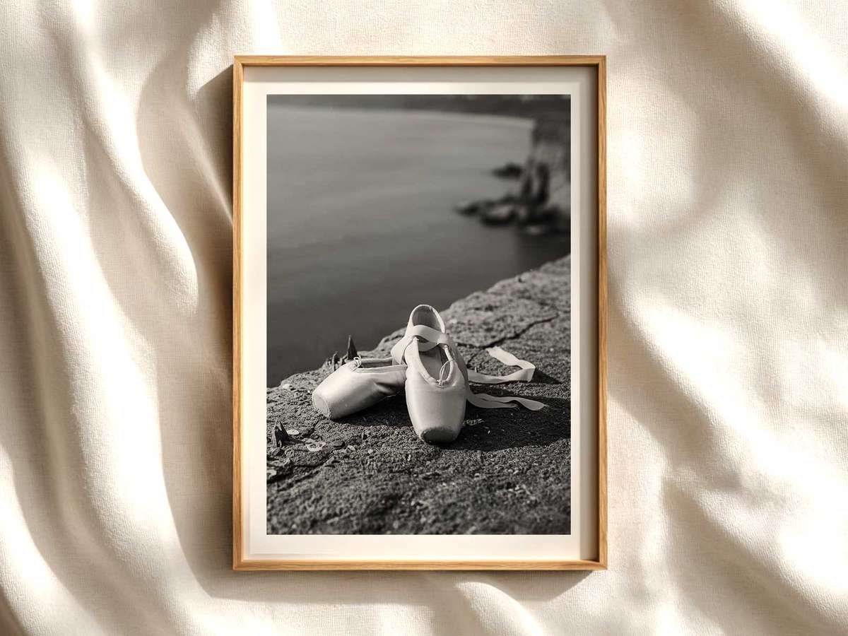 Close-up silhouette of a dancer en pointe highlighting foot shape and tension against a neutral background