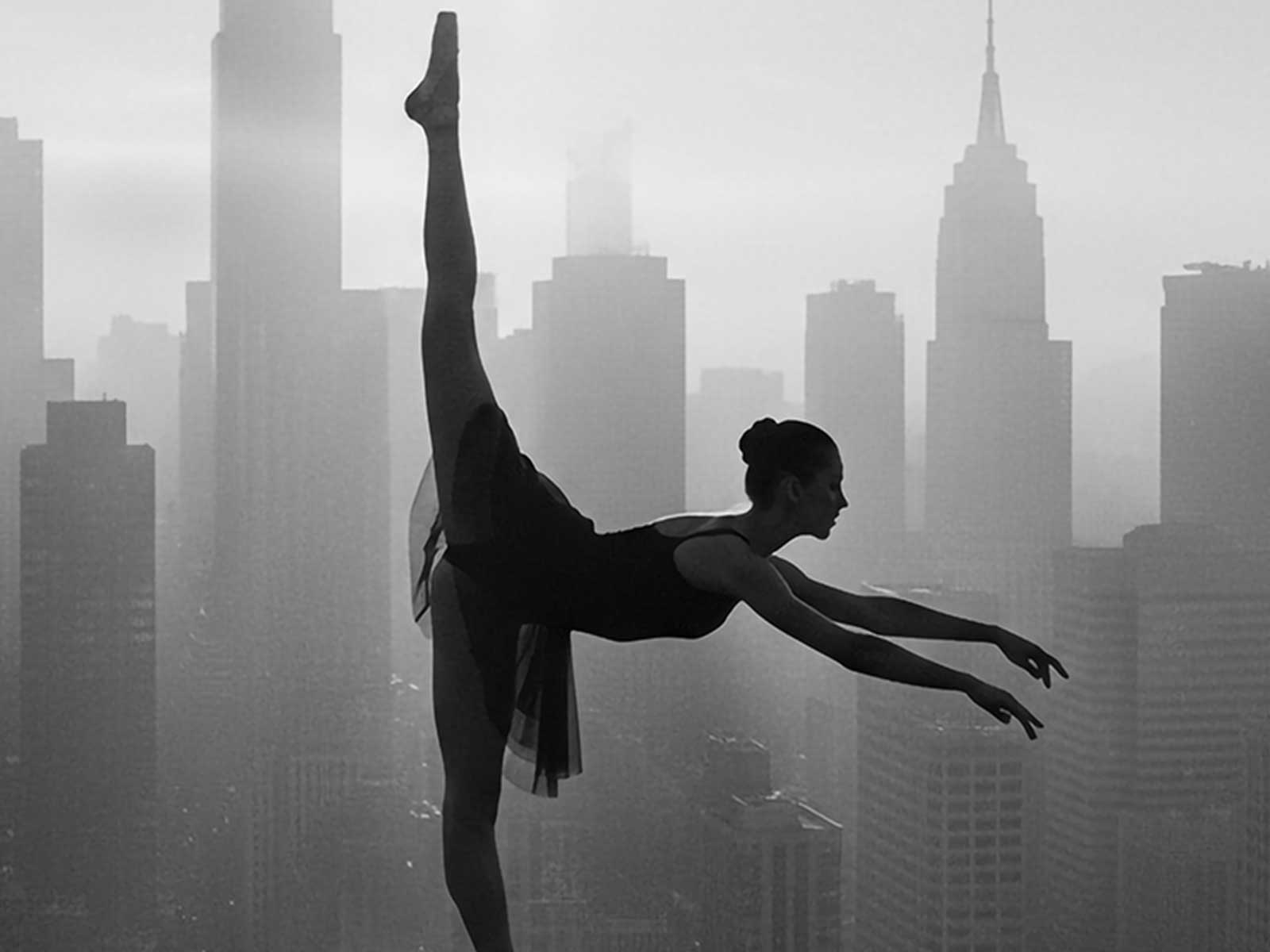 Close-up vertical composition of a ballerina's upper body and arms, her measured stance and refined silhouette filling the…