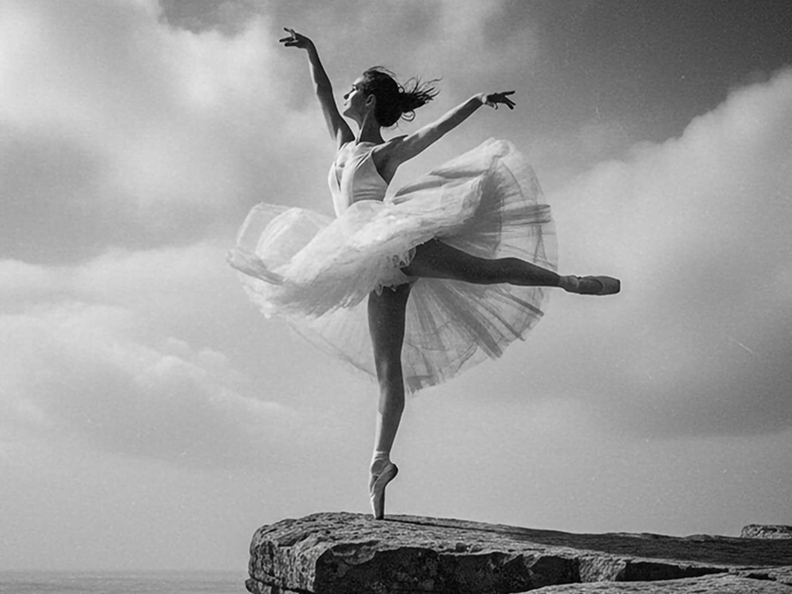 Dancer en pointe framed by a natural sea arch, rock formation providing a dramatic architectural backdrop