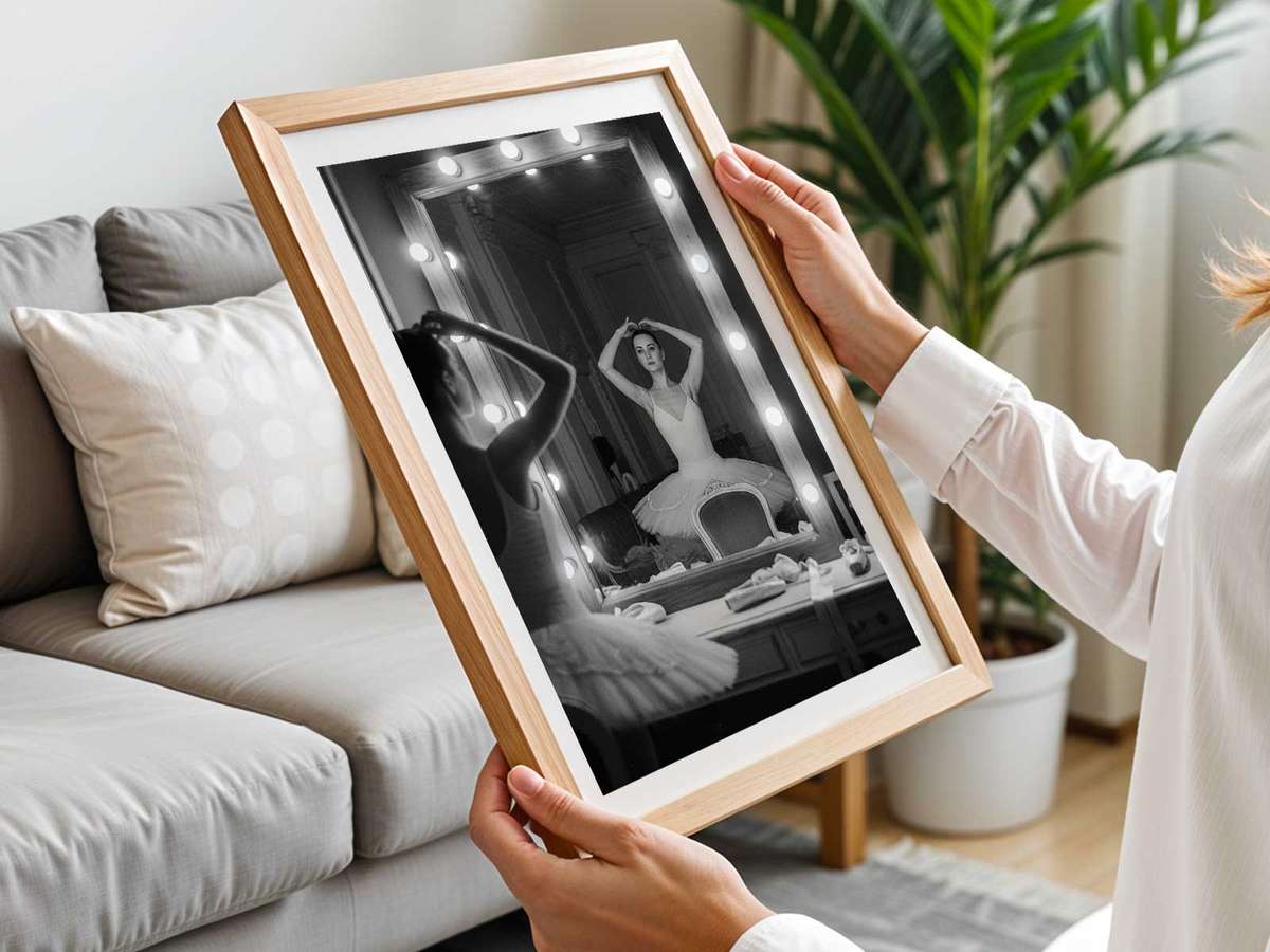 Low-contrast scene of a dancer and her reflected shadow in a dim studio, creating a layered composition of movement and…