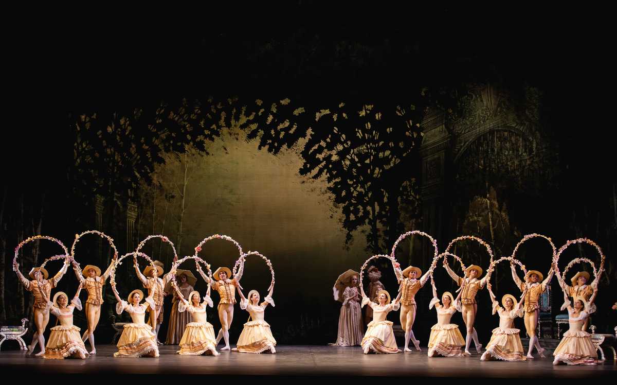 Lavish palace set of The Sleeping Beauty with chandeliers, velvet drapery and courtiers in period costume