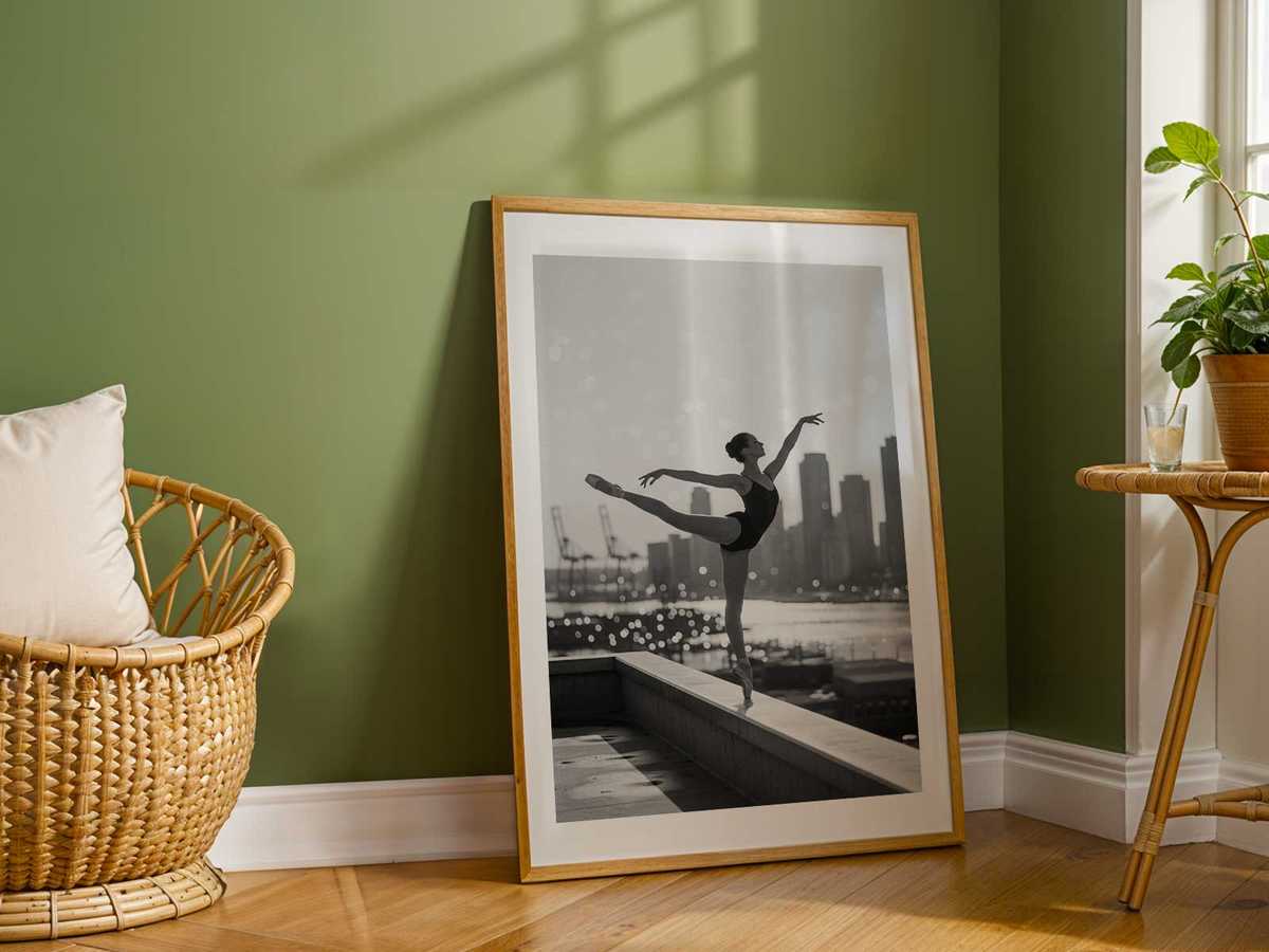 Wide view of a makeshift harbour stage where a ballerina performs under soft, golden light that evokes the calm of…