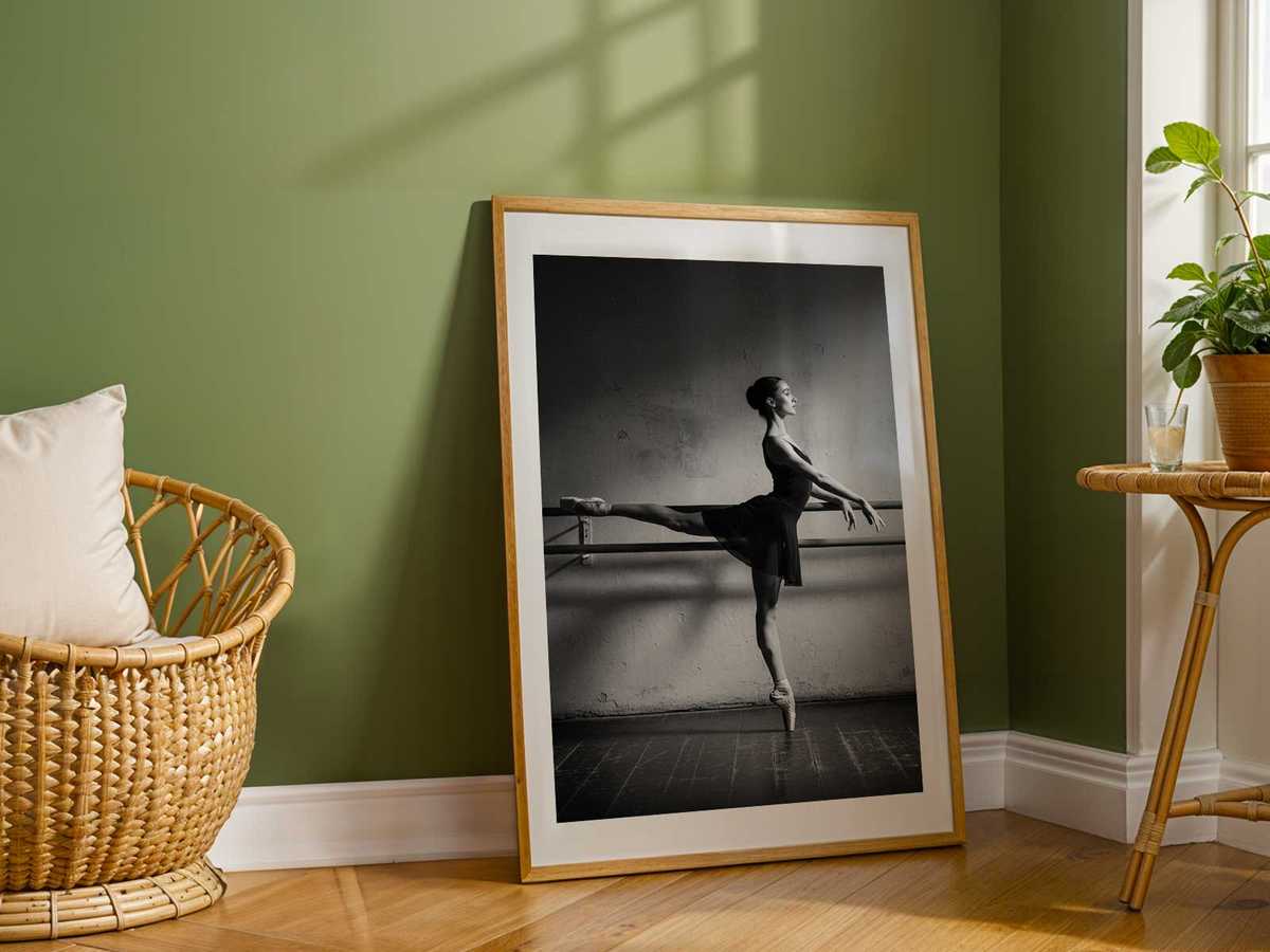 Ballet dancer seated on the studio floor catching breath, hands on knees, expression thoughtful
