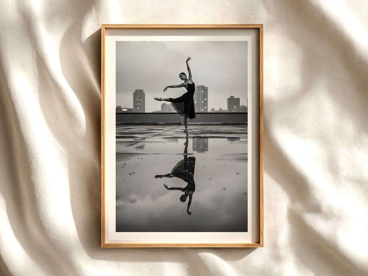 Ballerina poised on tiptoe against a soft urban skyline at dusk, emphasizing clean lines and lifted head