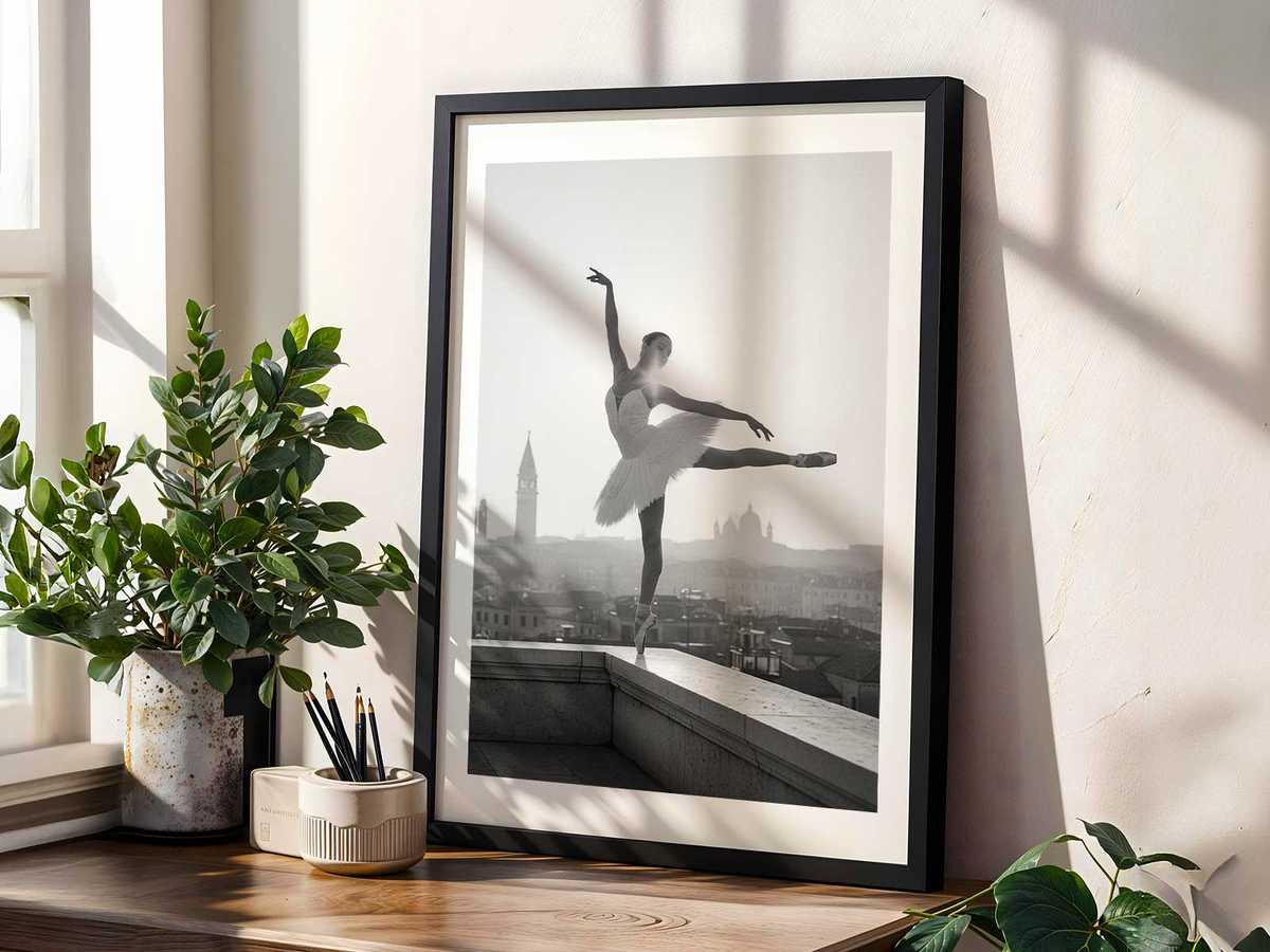 Female dancer performing a jeté along a waterfront with clear reflection in wet stone and moored gondolas